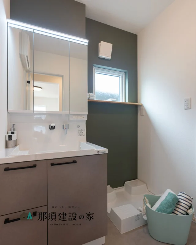 グリーンのアクセントクロスが個性を演出

小窓から光と風を取り込み
湿気がこもりにくくなっています

機能とデザインのバランスが取れた洗面空間です

----------------------------------------
暮らしを、無垢と。那須建設の家
----------------------------------------
「つくる」にマジメな家づくり

私たちは「人」に「くらし」に「住まい」にマジメです。
暮らしへのまっすぐな想いは、家づくりへとつながり
木が持つ自然の力をいかす無垢の家にたどり着きました。

ただひたすらに、良い住まいを。
その答えが、私たちの「無垢の家づくり」です。
数多くの現場で培った技術やノウハウをもとに、
住む人の声に耳を傾けつづけます。

「おもい」をともに、つくる
「いいな」をともに、つくる
「くらし」をともに、つくる

住むほどに味わい深くなる無垢の住まいを
ぜひ、私たちとご一緒に。
暮らしを、無垢と。
那須建設の家
----------------------------------------
【最新情報や施工事例はHPにて】
プロフィールのリンクより
@mukunoiedukuri_nas
----------------------------------------　　
#那須建設の家
#暮らしを無垢と
#注文住宅
#無垢の家
#洗面所インテリア
#洗面所収納
#アクセントクロス