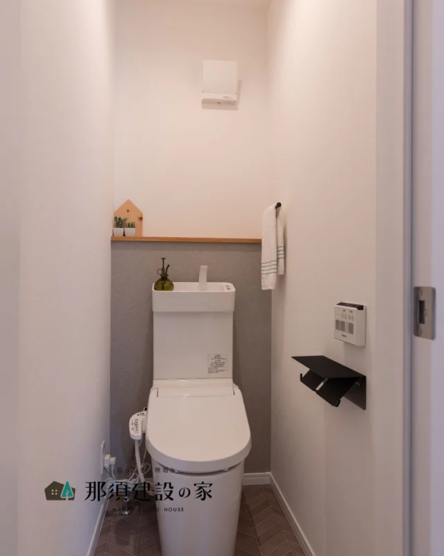 グレーのクロスとヘリンボーン柄の床が上品なトイレ空間

奥の棚にはお気に入りの雑貨をさりげなく飾って
気分が上がるスペースに

----------------------------------------
暮らしを、無垢と。那須建設の家
----------------------------------------
「つくる」にマジメな家づくり

私たちは「人」に「くらし」に「住まい」にマジメです。
暮らしへのまっすぐな想いは、家づくりへとつながり
木が持つ自然の力をいかす無垢の家にたどり着きました。

ただひたすらに、良い住まいを。
その答えが、私たちの「無垢の家づくり」です。
数多くの現場で培った技術やノウハウをもとに、
住む人の声に耳を傾けつづけます。

「おもい」をともに、つくる
「いいな」をともに、つくる
「くらし」をともに、つくる

住むほどに味わい深くなる無垢の住まいを
ぜひ、私たちとご一緒に。
暮らしを、無垢と。
那須建設の家
----------------------------------------
【最新情報や施工事例はHPにて】
プロフィールのリンクより
@mukunoiedukuri_nas
----------------------------------------　　
#那須建設の家
#暮らしを無垢と
#注文住宅
#無垢の家
#トイレインテリア
#トイレクロス
#トイレ照明