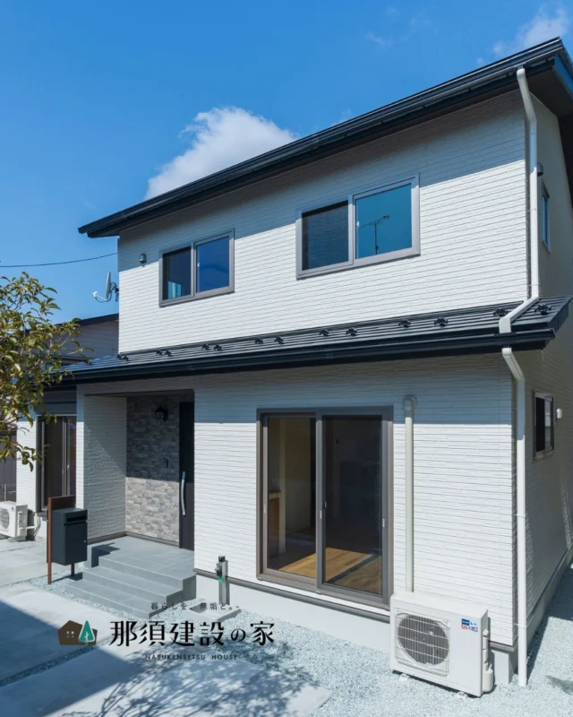 爽やかなホワイトの外壁をメインに
玄関まわりには濃色の外壁を組み合わせて
メリハリのある上品な外観デザインに

宅配ボックスを玄関近くに配置し
日々の使いやすさにも配慮しました

----------------------------------------
暮らしを、無垢と。那須建設の家
----------------------------------------
「つくる」にマジメな家づくり

私たちは「人」に「くらし」に「住まい」にマジメです。
暮らしへのまっすぐな想いは、家づくりへとつながり
木が持つ自然の力をいかす無垢の家にたどり着きました。

ただひたすらに、良い住まいを。
その答えが、私たちの「無垢の家づくり」です。
数多くの現場で培った技術やノウハウをもとに、
住む人の声に耳を傾けつづけます。

「おもい」をともに、つくる
「いいな」をともに、つくる
「くらし」をともに、つくる

住むほどに味わい深くなる無垢の住まいを
ぜひ、私たちとご一緒に。
暮らしを、無垢と。
那須建設の家
----------------------------------------
【最新情報や施工事例はHPにて】
プロフィールのリンクより
@mukunoiedukuri_nas
----------------------------------------　　
#那須建設の家
#暮らしを無垢と
#注文住宅
#無垢の家
#外観デザイン
#サイディング
#外観おしゃれ